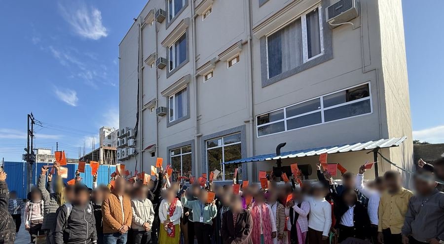 Students and teachers on an educational trip, gathered outside the Amartarangini Hotel building in Haridwar
